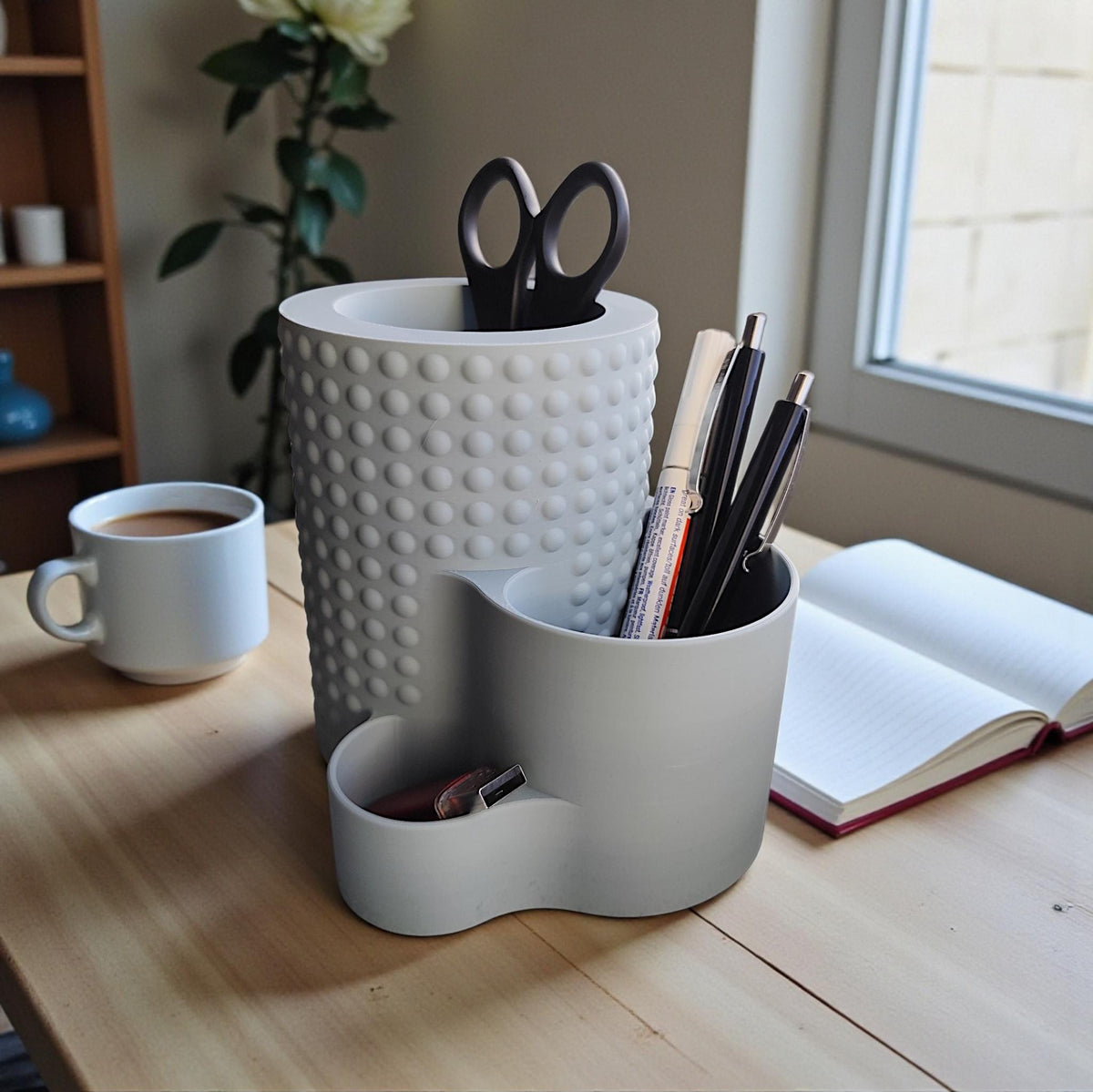Grey tiered dimple pencil pot holding scissors and pens on a wooden desk