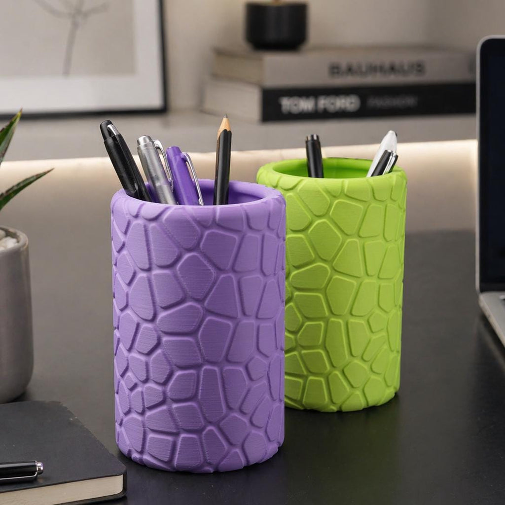 Purple and lime geometric pencil pots holding pens on a desk