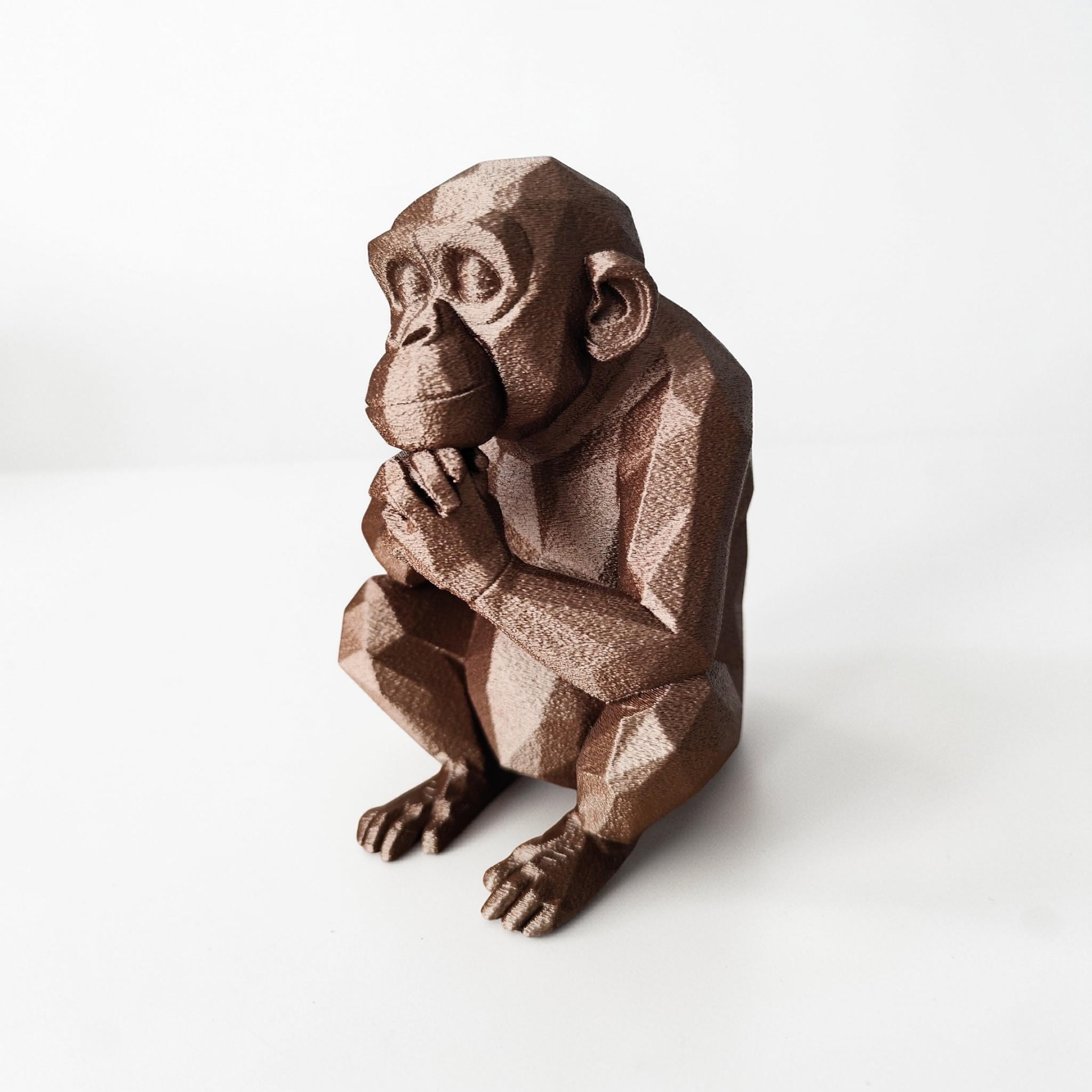 Brown monkey figurine holding a banana on a white background