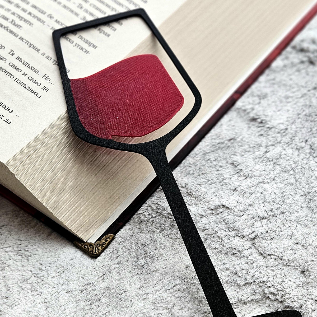 Wine glass bookmark on an open book, close up