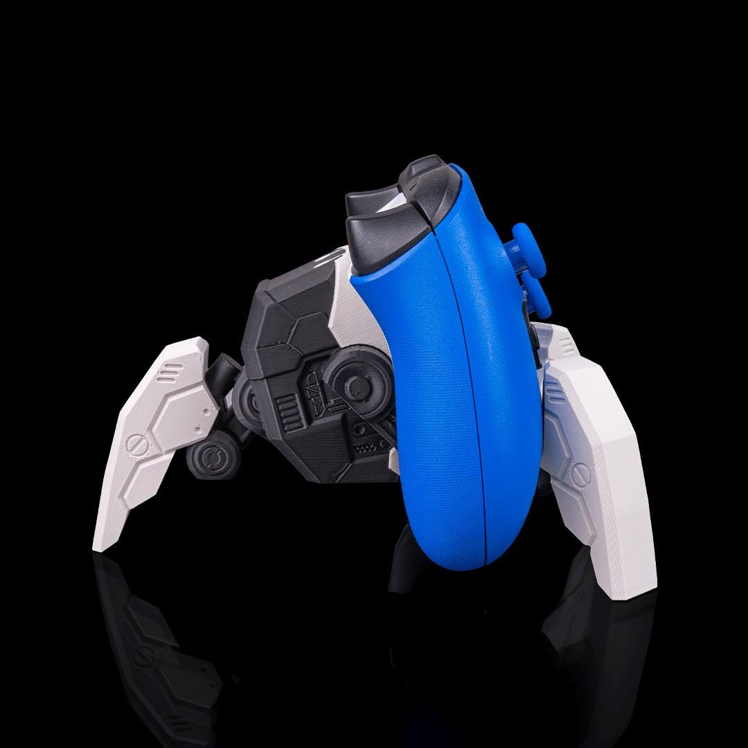 Robot spider stand from the side, holding a blue Xbox controller