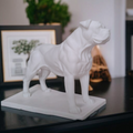 White dog statue on a dark surface with a blurred background