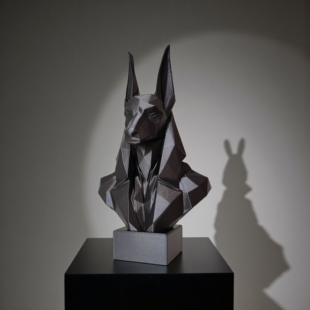 Geometric sculpture of a dog head on a black pedestal with a gray background