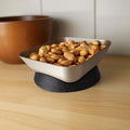 Bowl filled with snacks on a wooden surface