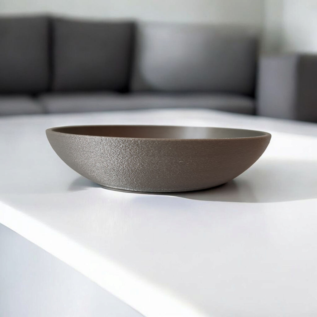 Brown bowl on a white surface with a blurred gray sofa in the background