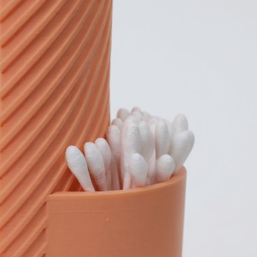 Orange container with cotton swabs on a light gray background