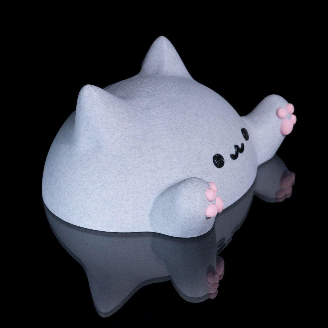 Gray plush toy with a happy face on a black background