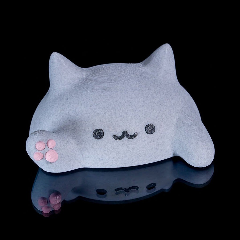 Gray cat-shaped object with a cute face on a black background