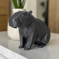 Geometric 3D printed capybara statue on a minimalist desk with a plant.
