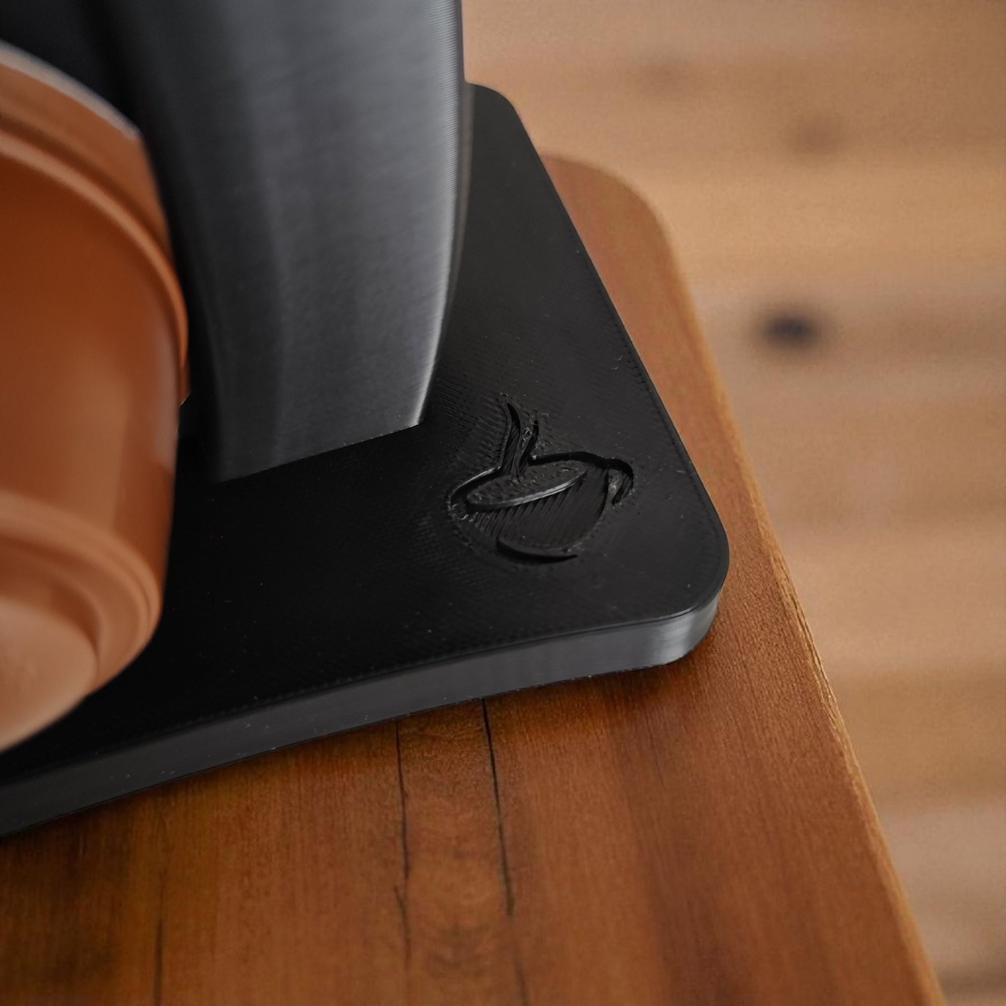 Close-up of the capsule holder showing the wavy design and embossed coffee cup.