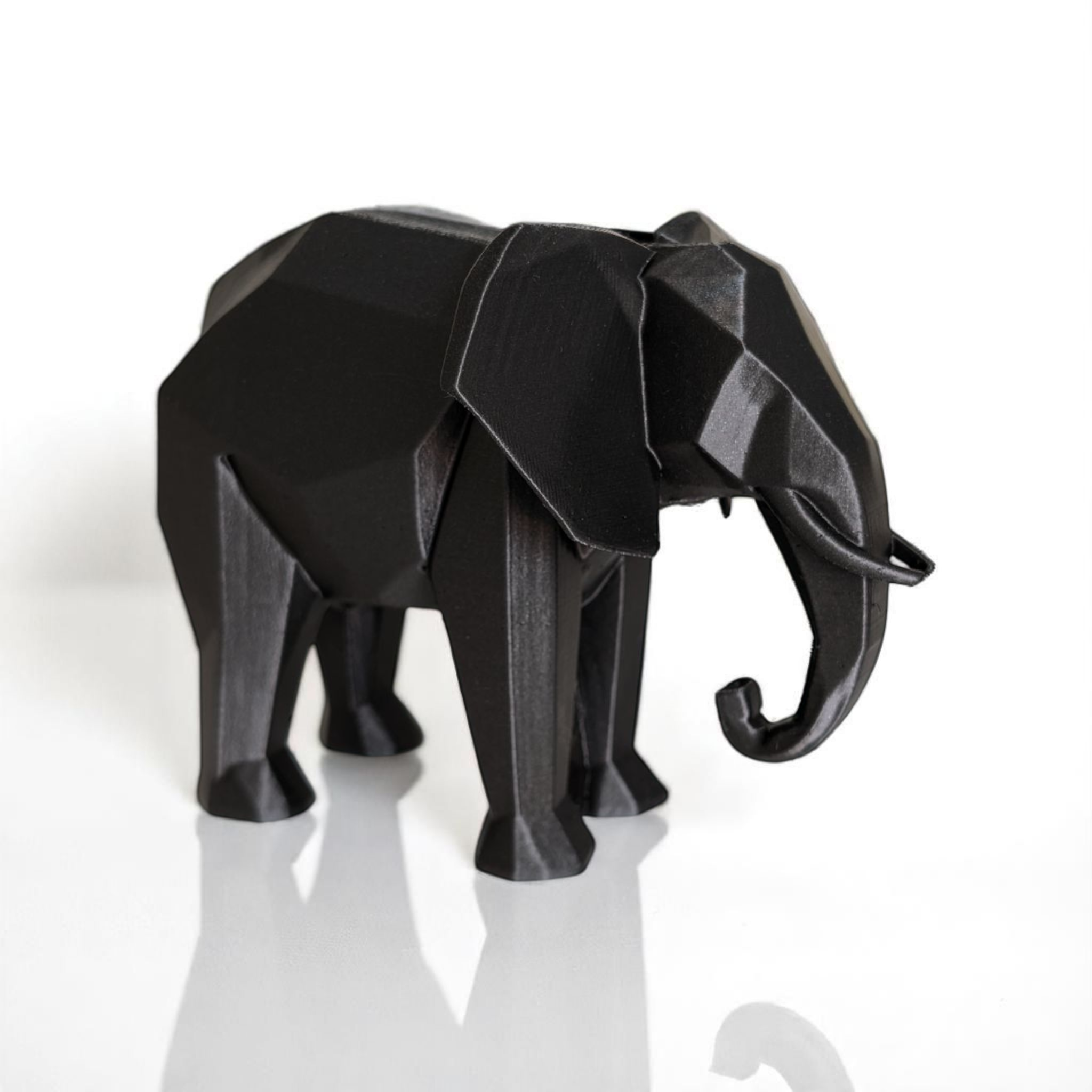 Black elephant sculpture on a white background