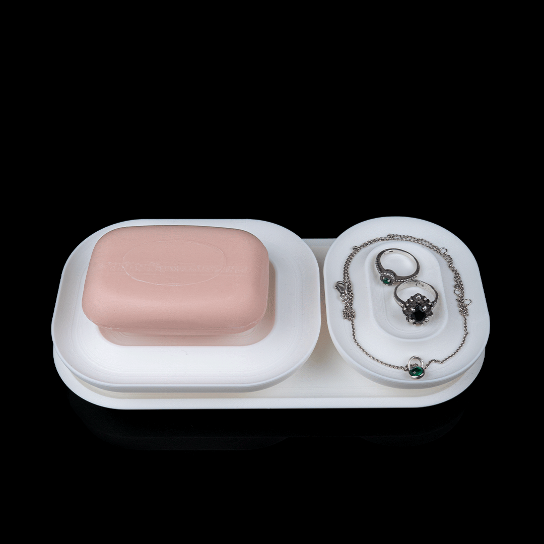White jewelry tray with a pink soap bar and jewelry on a black background