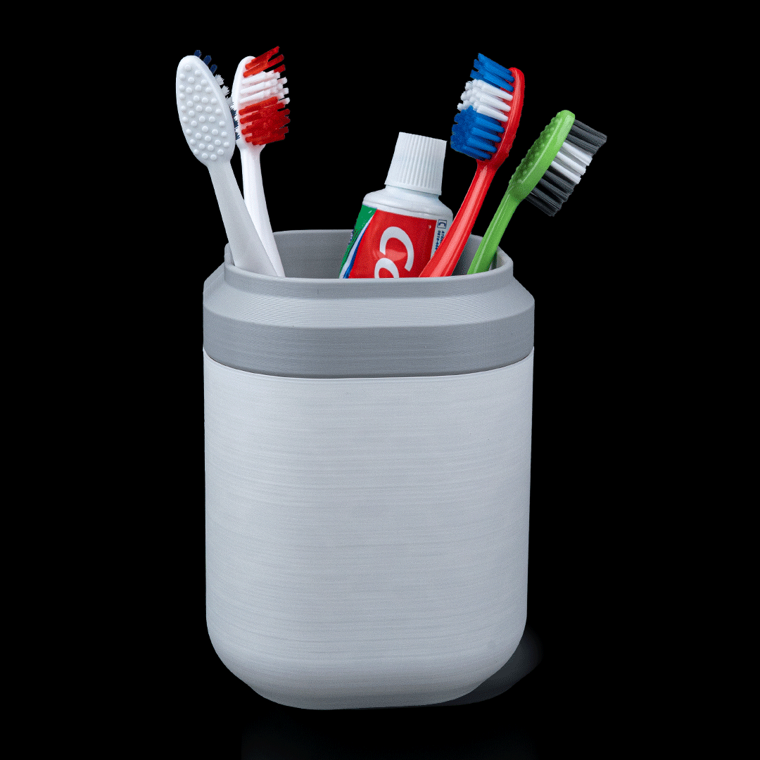 Gray toothbrush holder with toothbrushes and toothpaste on a black background