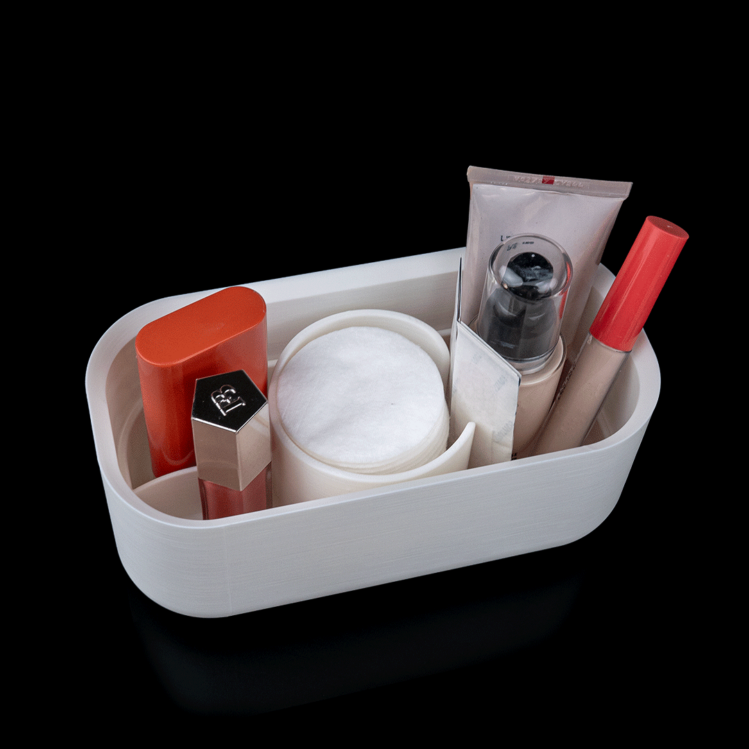 White rectangular container holding various cosmetic items on a black background