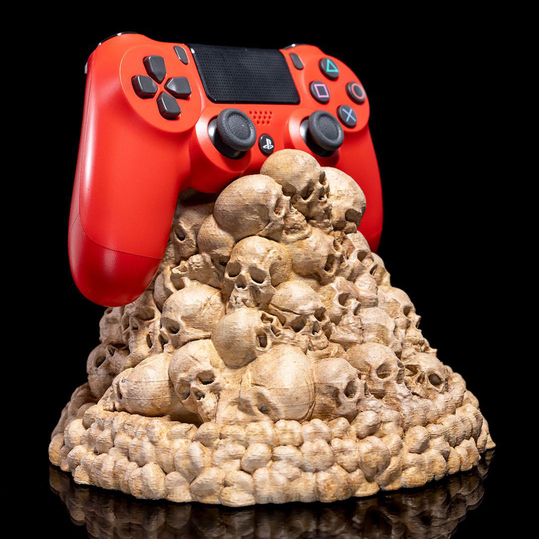Gaming controller resting on Fate of the Fallen skull pile stand - side view with PlayStation or Xbox controller