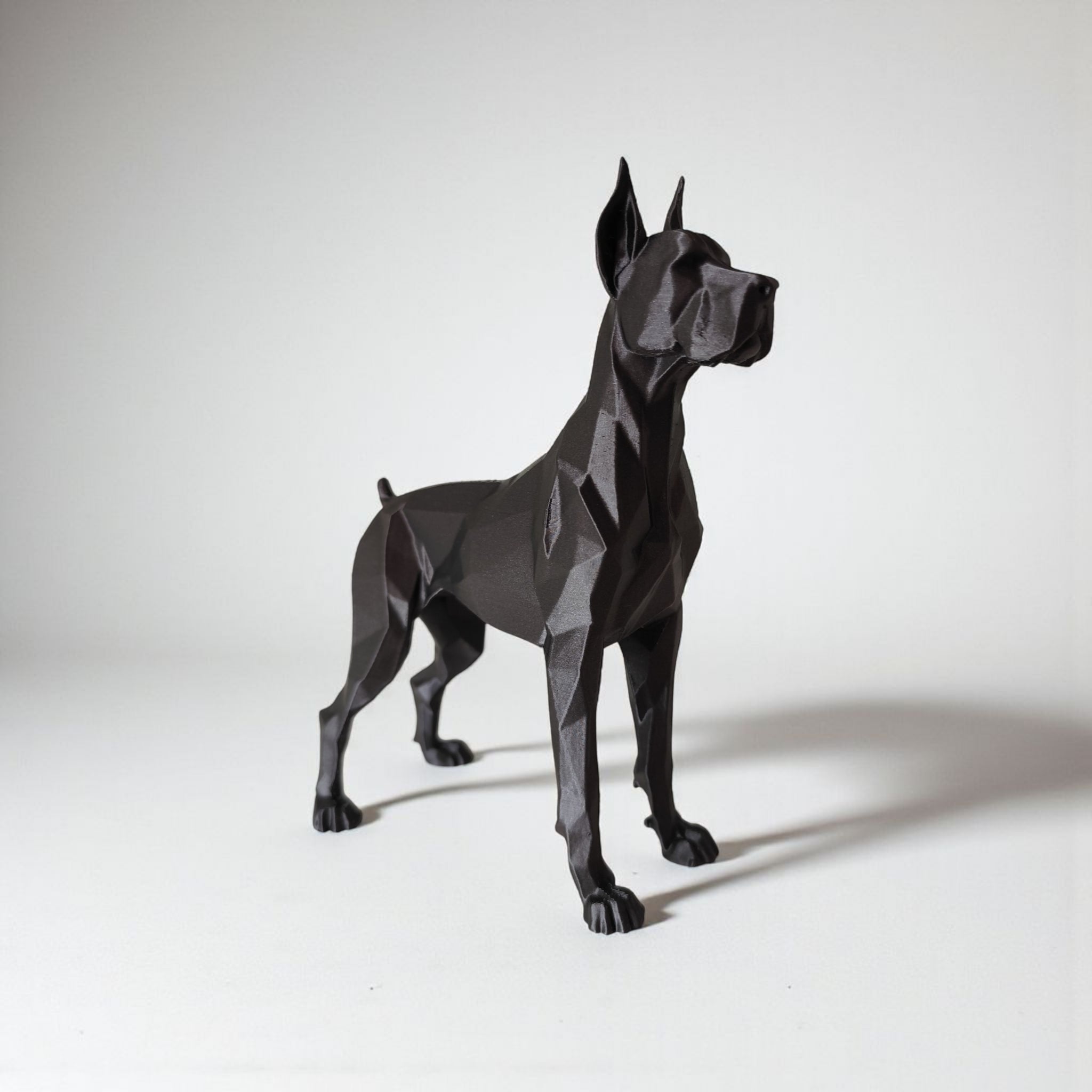 Black geometric dog sculpture on a white background