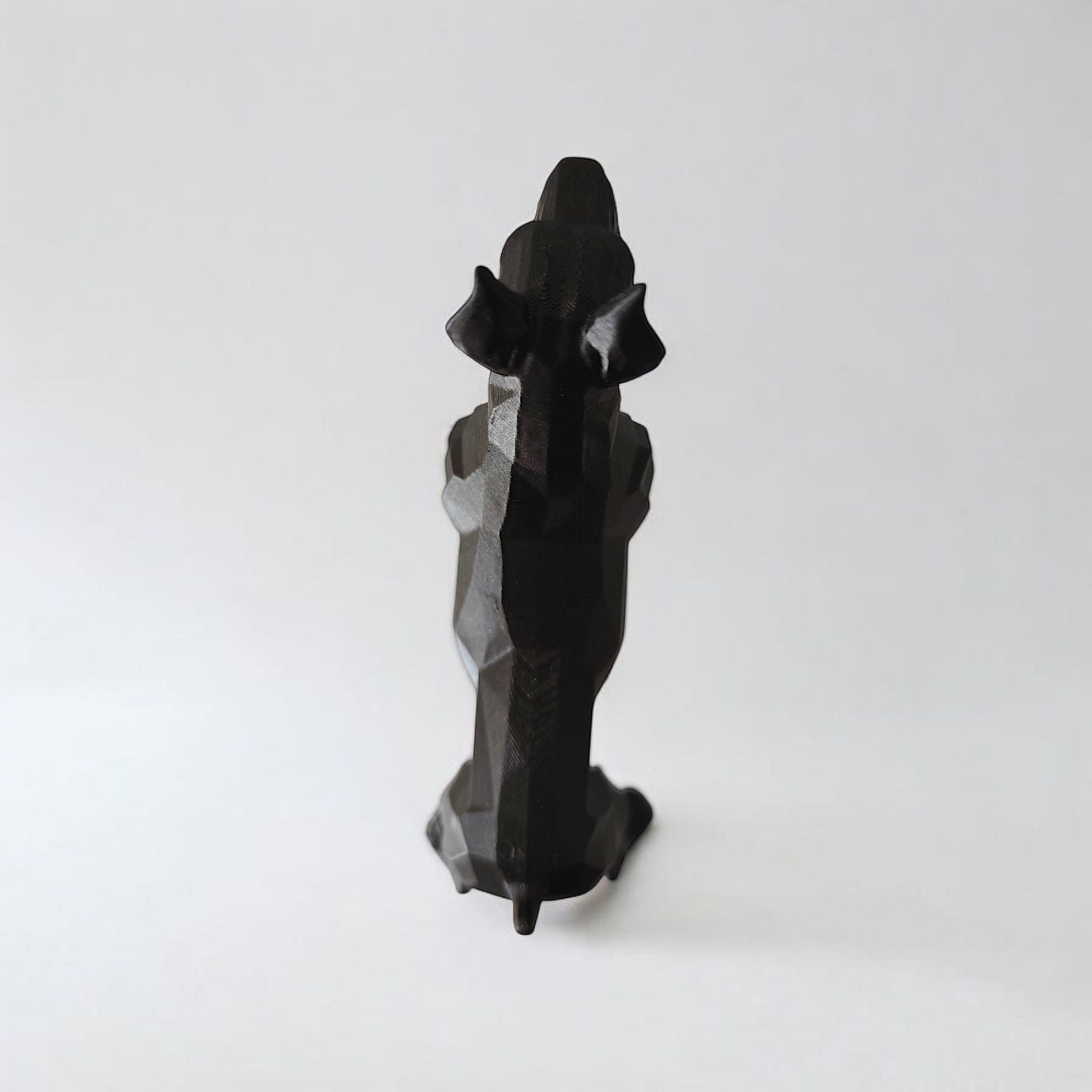 Black geometric sculpture on a white background