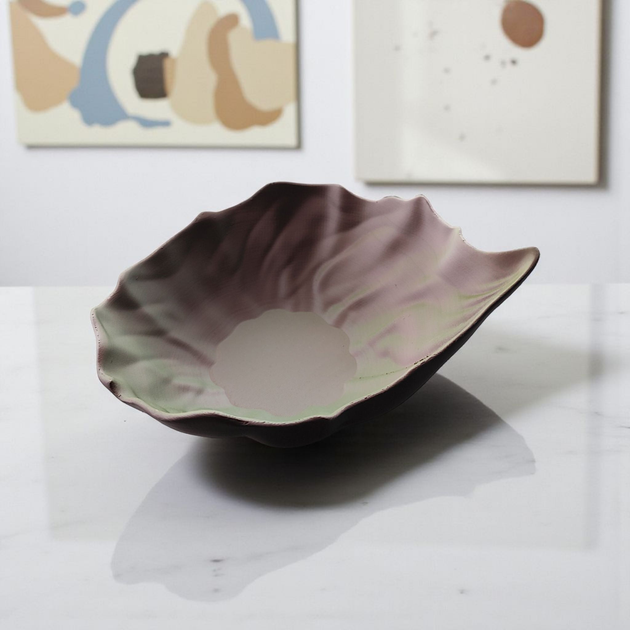Plastic leaf-shaped bowl on a marble surface with abstract art in the background