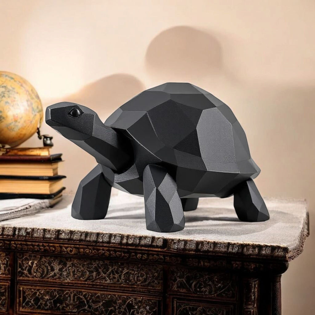Geometric black turtle sculpture on a decorative table with books and a globe in the background.