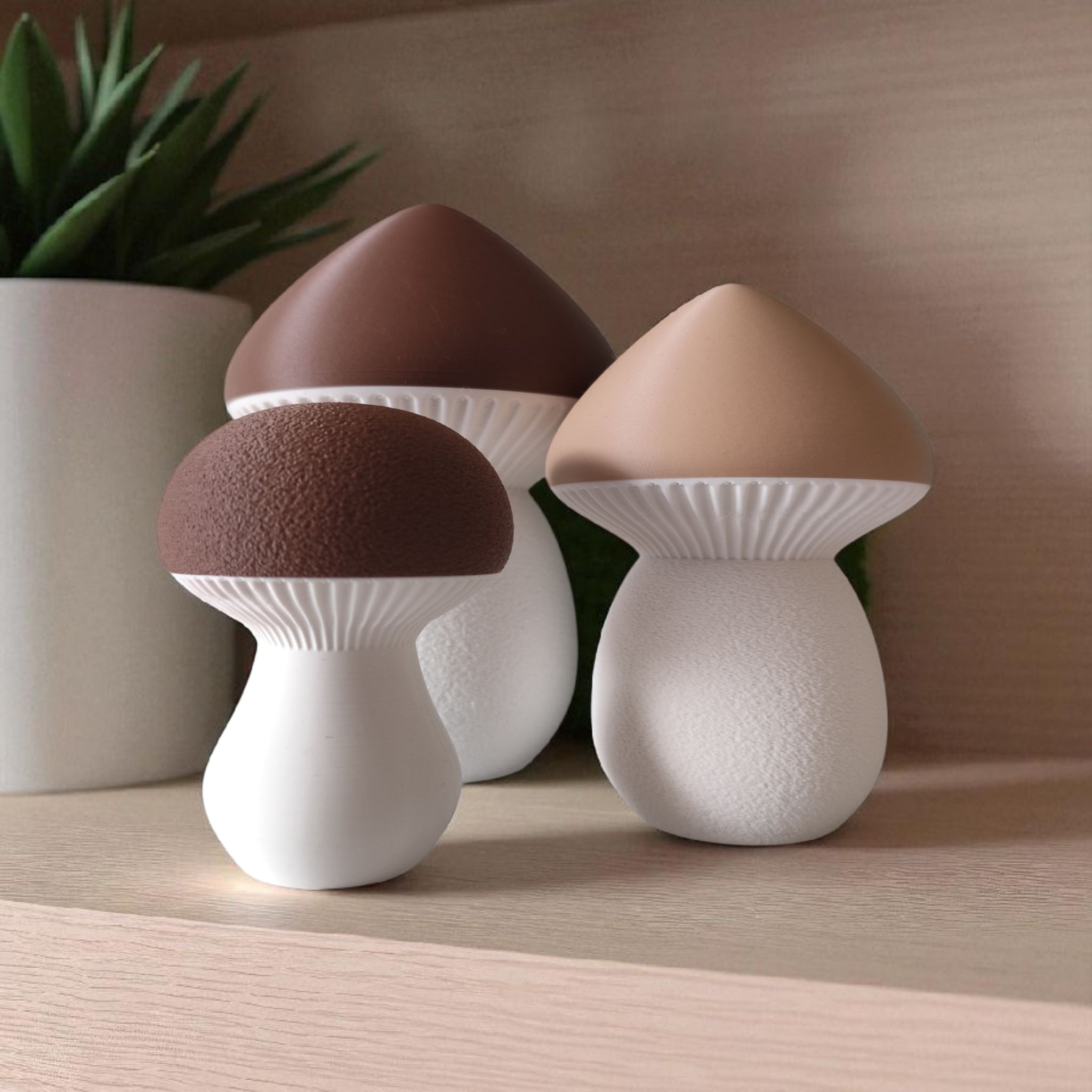 Three mushroom-shaped lamps with brown caps and white bases on a wooden surface.