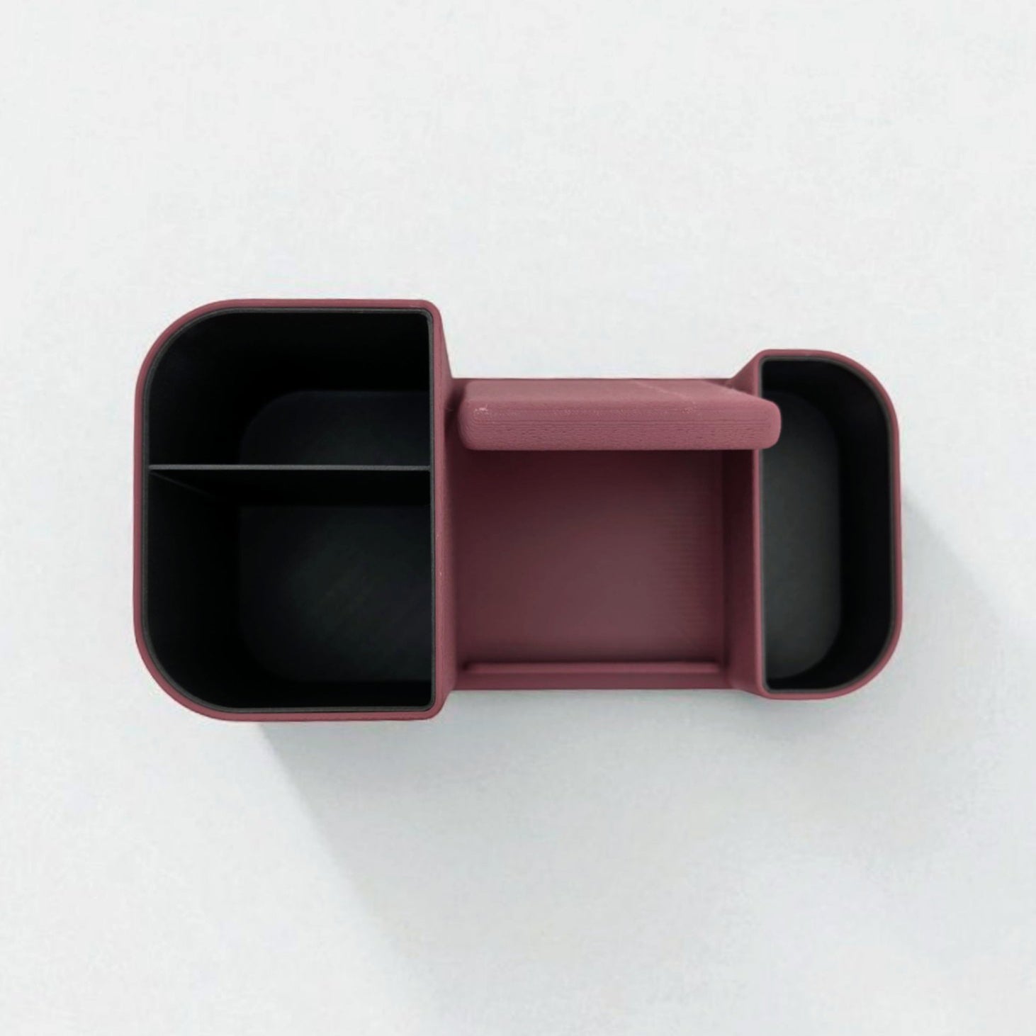Maroon bento box with black interior compartments on a white background