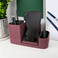 Purple desk organizer with phone stand, pen holder, and scissors on a white surface.