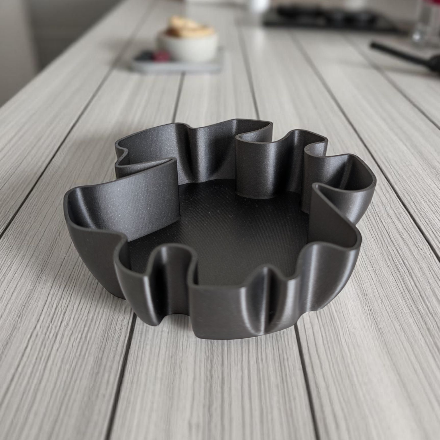 Black wavy bowl on a wooden surface