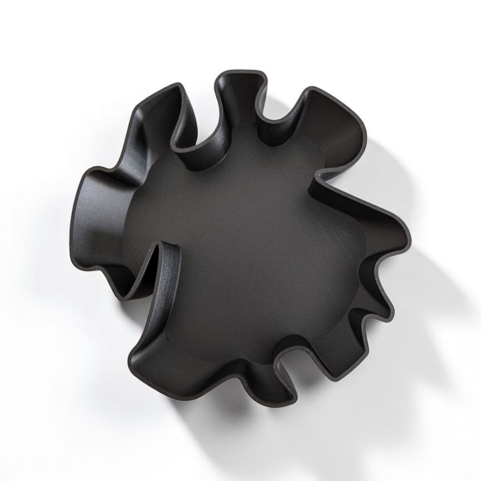 Black, sun-shaped object on a white background