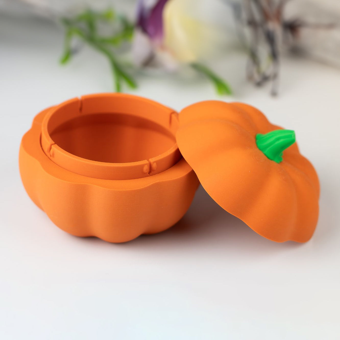 Pumpkin-shaped container with a green stem on a white background