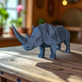 Blue geometric rhinoceros model on a wooden surface with a blurred indoor background