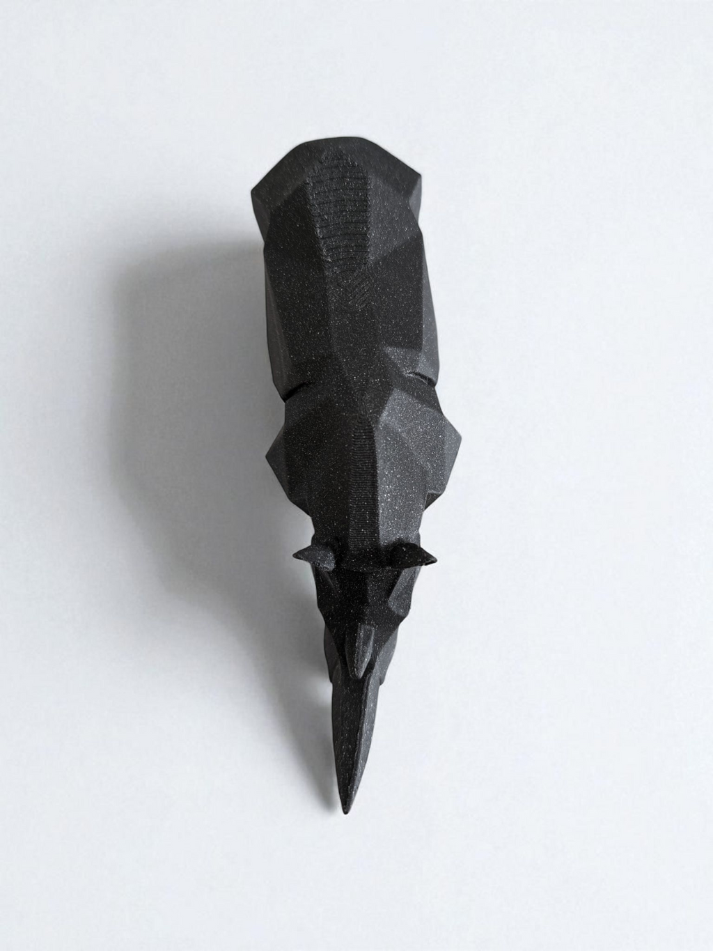 Black geometric sculpture on a white background