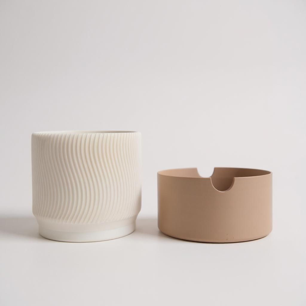 Two ceramic containers, one white with ribbed texture and the other beige, on a light gray background.