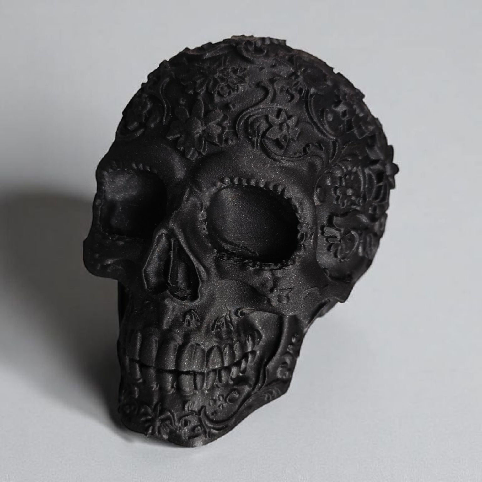 Black skull with intricate designs on a gray background