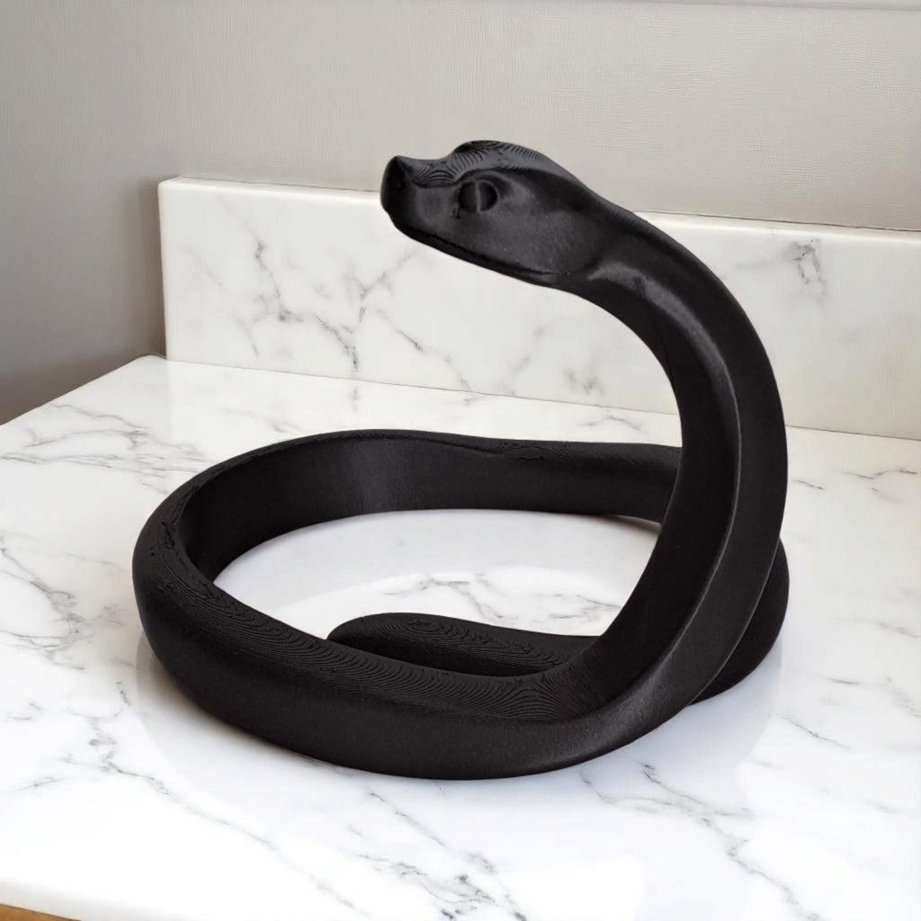 Close-up of the 3D-printed snake figure showing its geometric, faceted design.