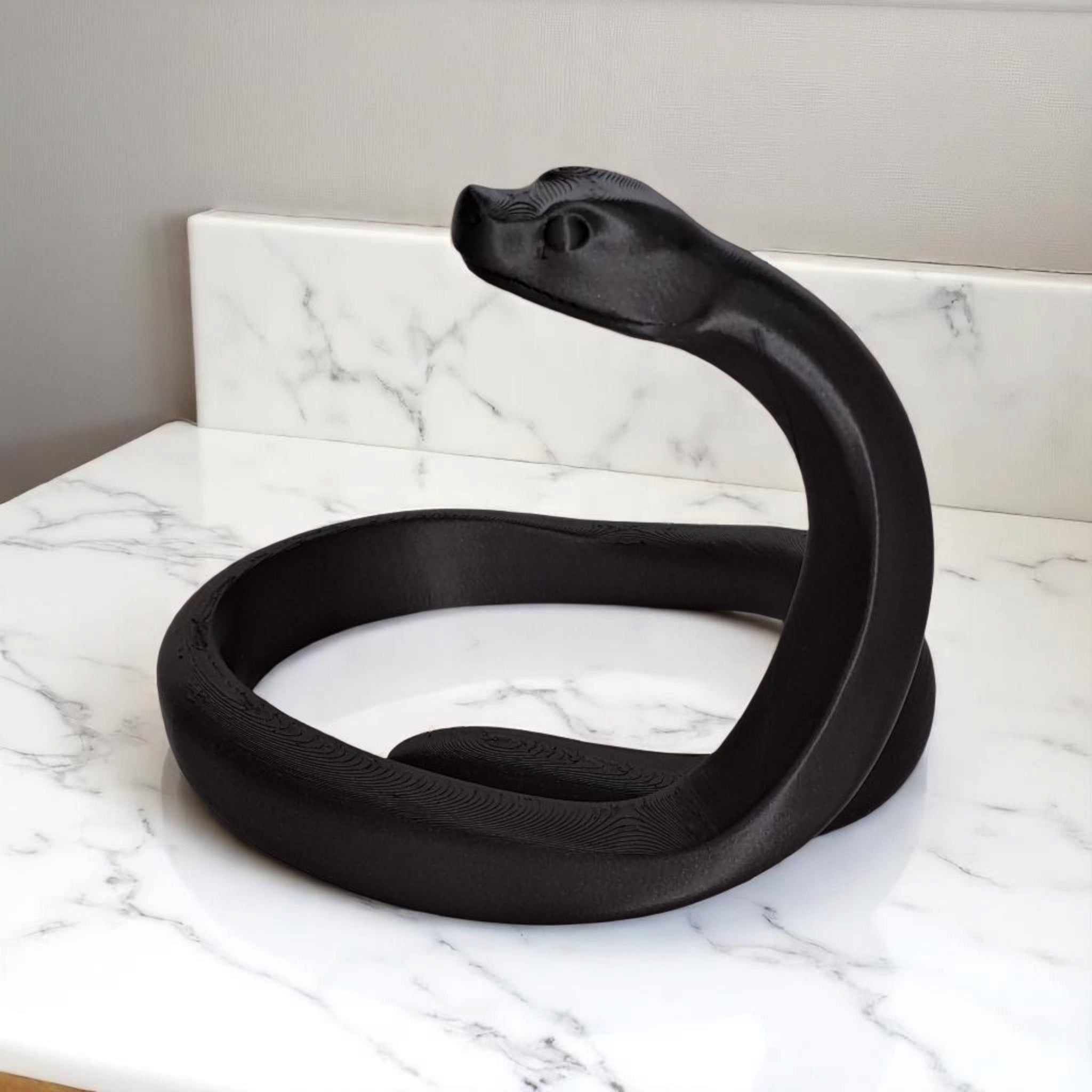 Close-up of the 3D-printed snake figure showing its geometric, faceted design.