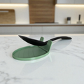 The CookSitter silicone spoon rest holding a wooden spoon on a kitchen counter.