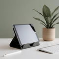 Tablet on a stand with a plant and keyboard on a desk