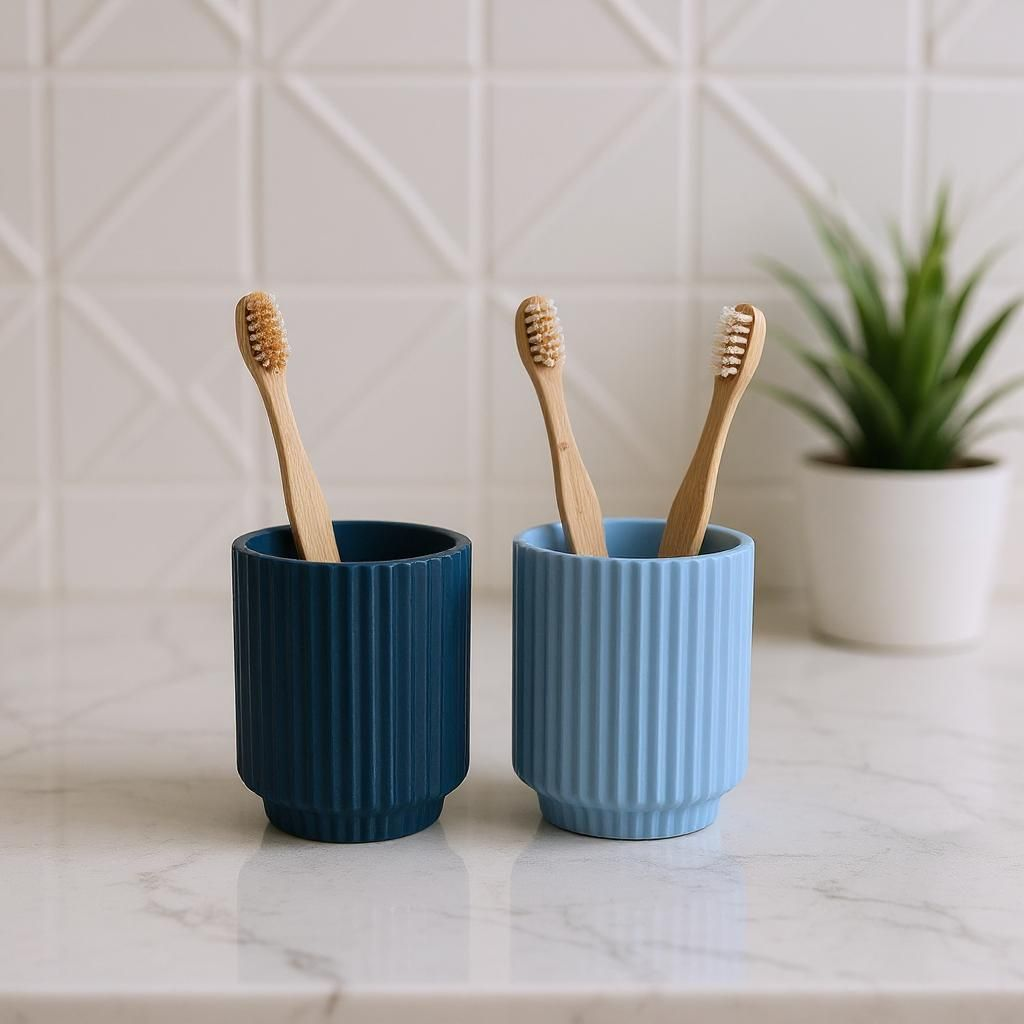 Two ribbed cups holding toothbrushes and toothpaste.