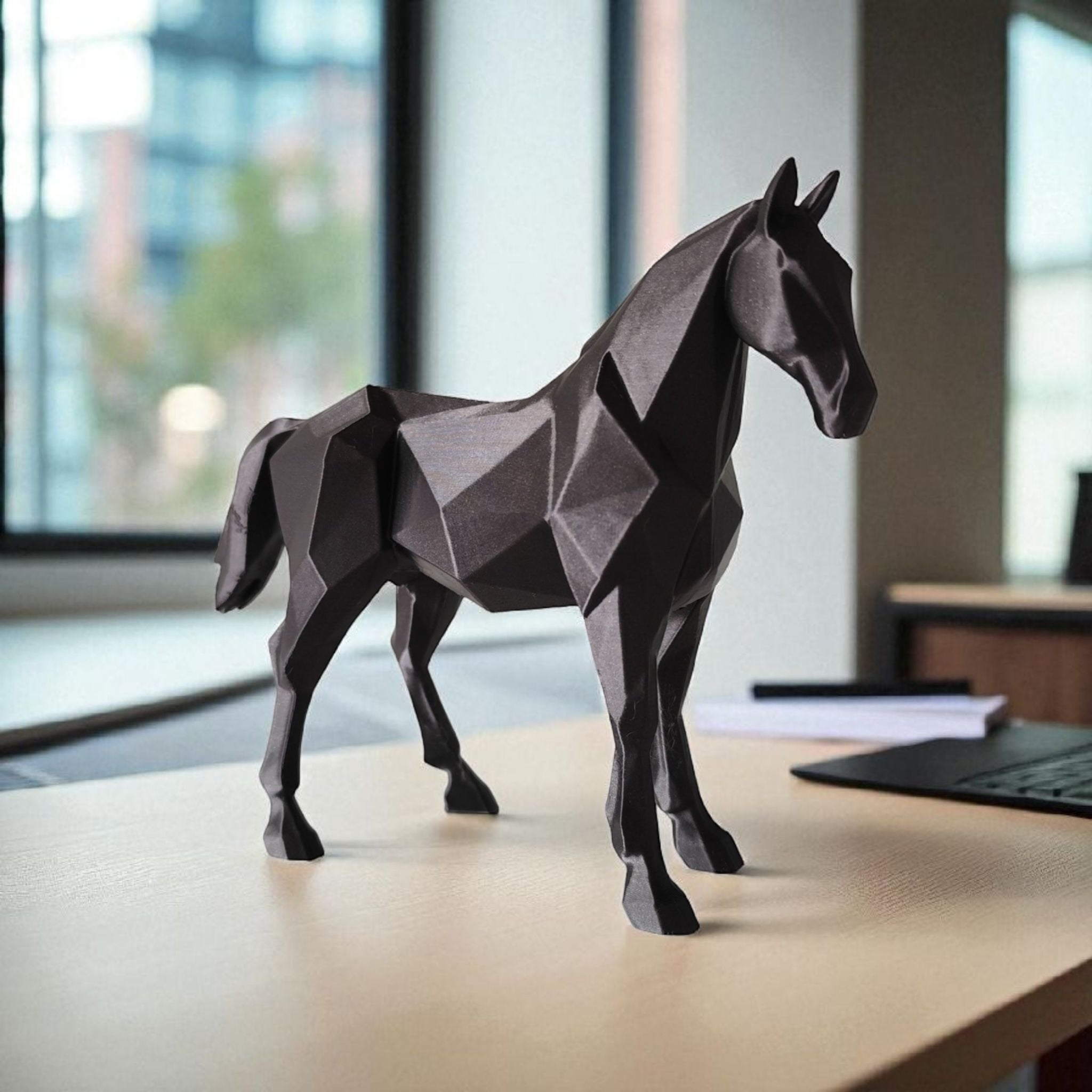 Geometric horse sculpture on a desk with a blurred office background