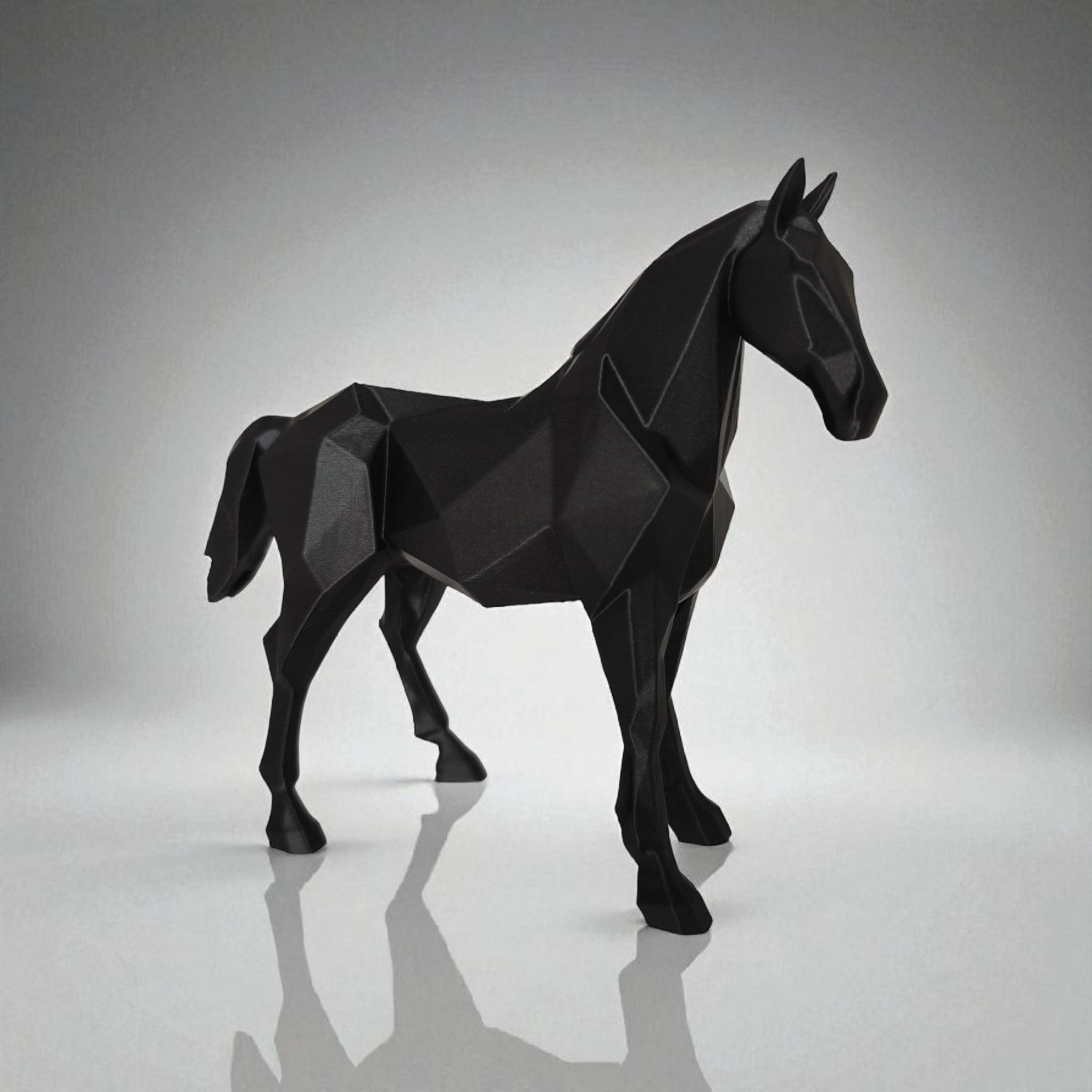 Black geometric horse sculpture on a reflective surface with a gray background