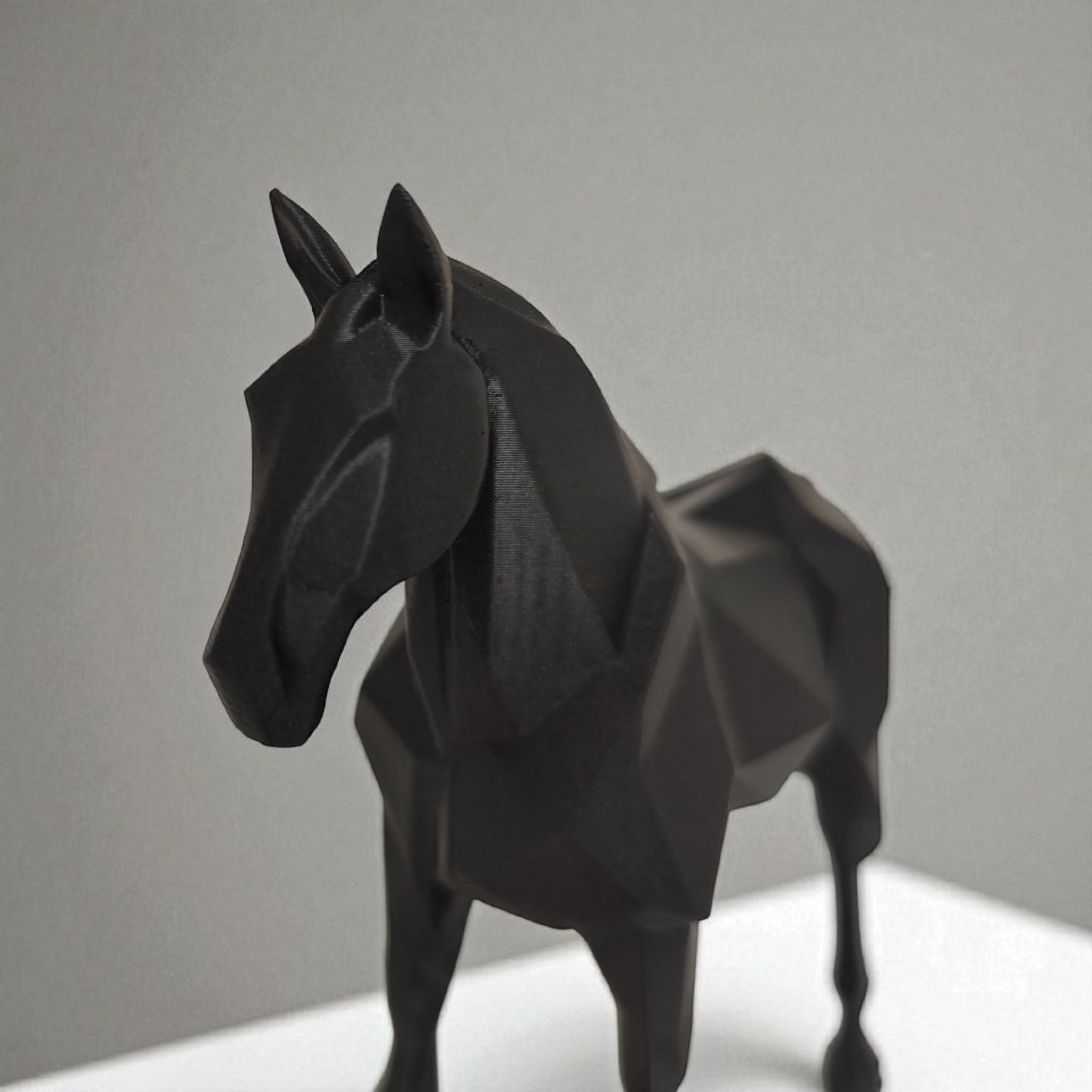 Black horse sculpture on a gray background