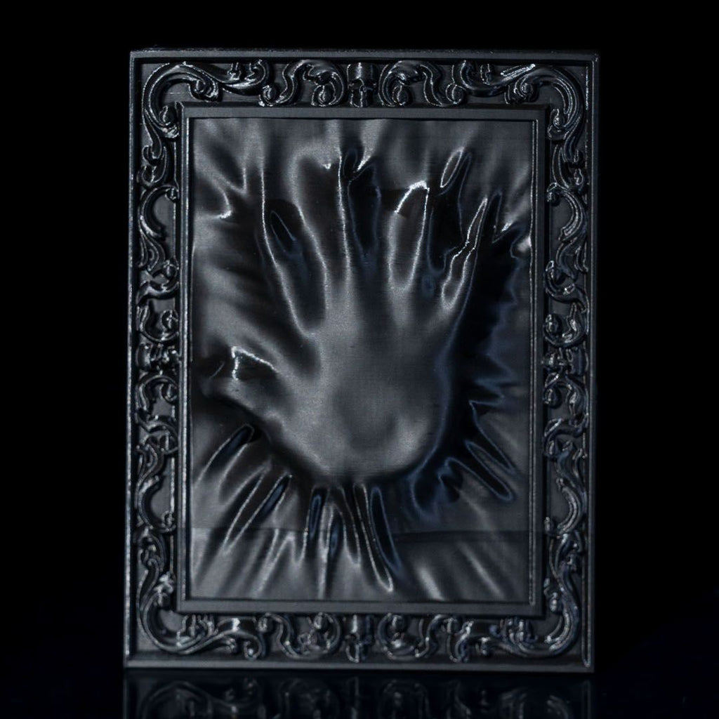 Decorative black frame with a hand-shaped cutout on a black background