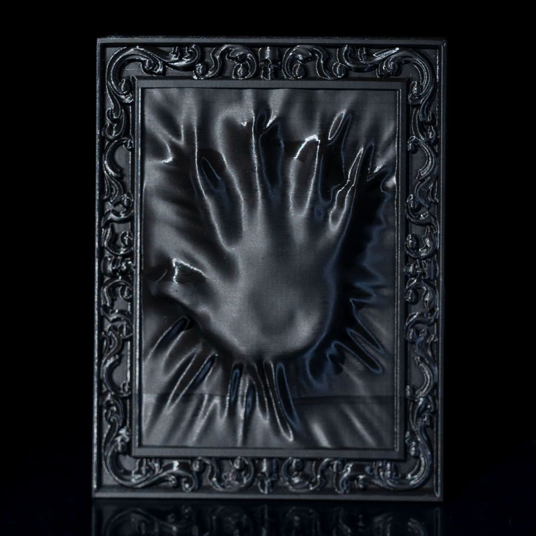 Decorative black frame with a hand-shaped cutout on a black background