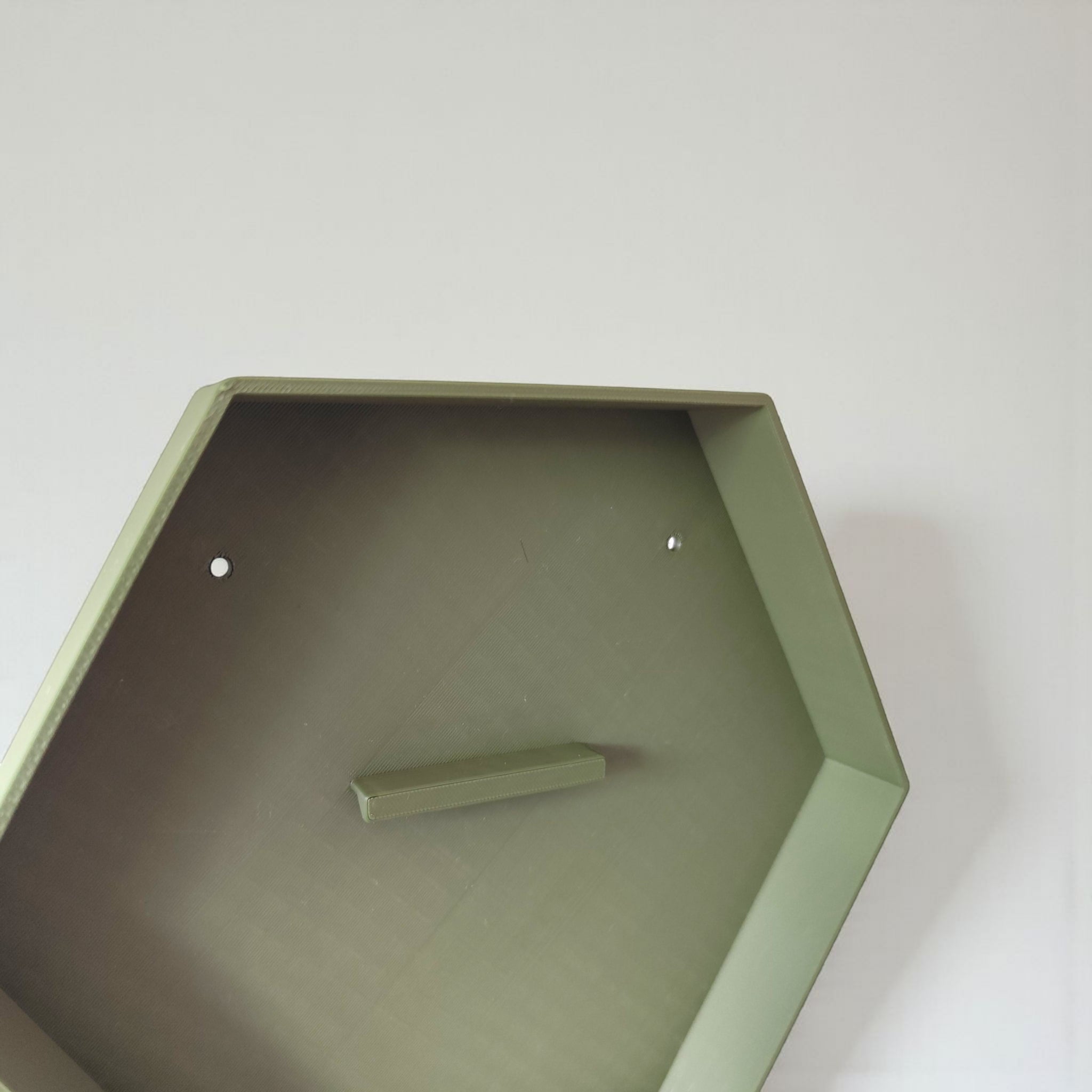 Hexagonal green shelf on a white wall