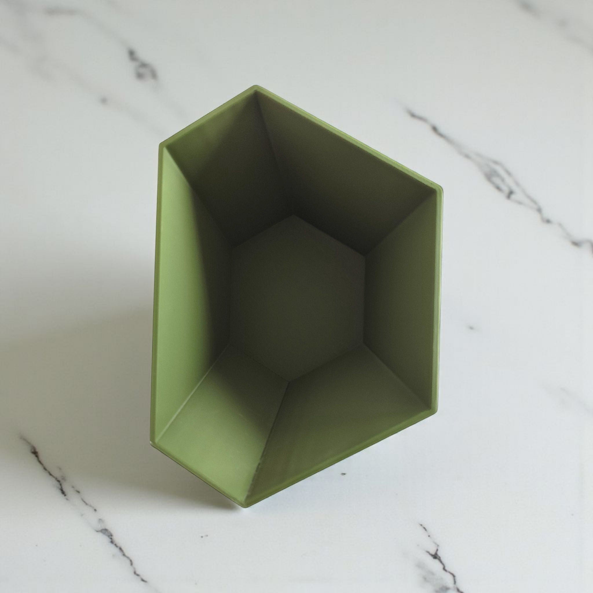 Green geometric planter on a marble surface