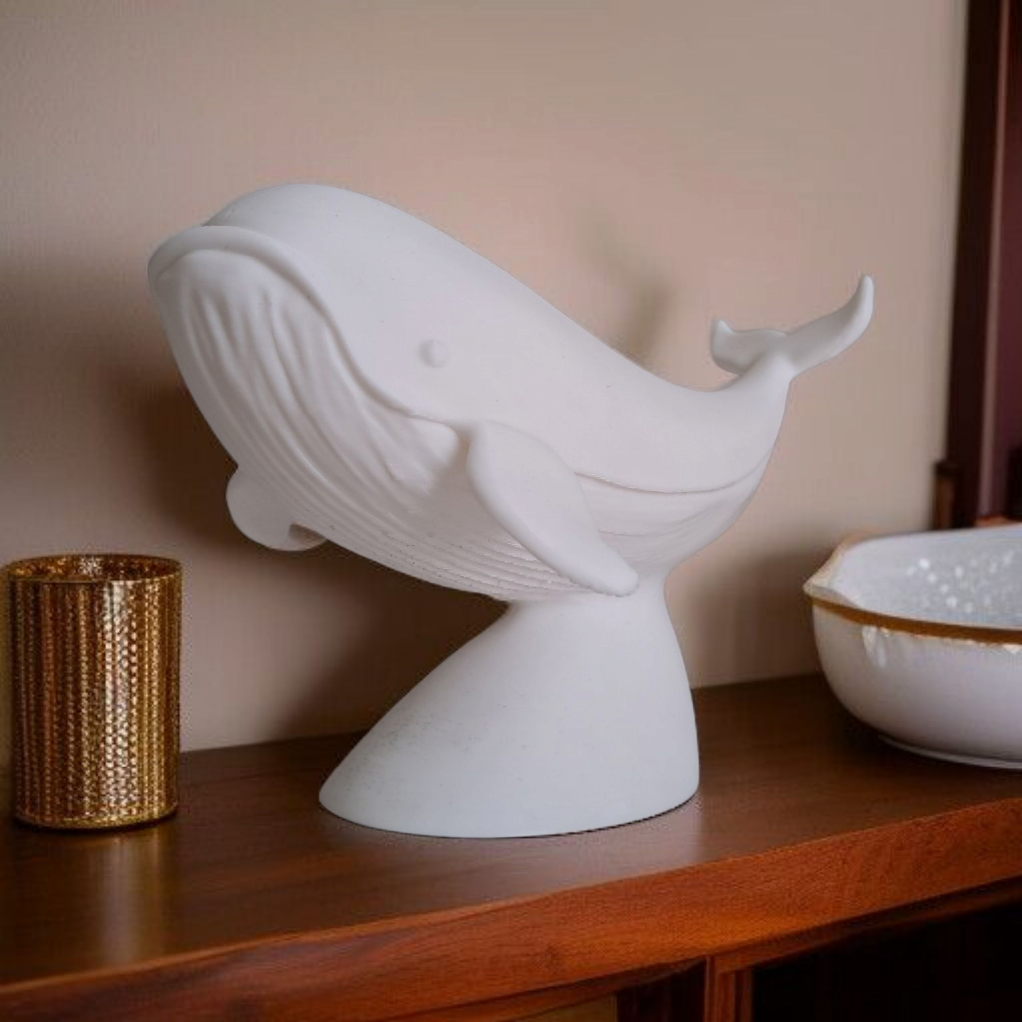 White whale sculpture on a wooden surface with a neutral background
