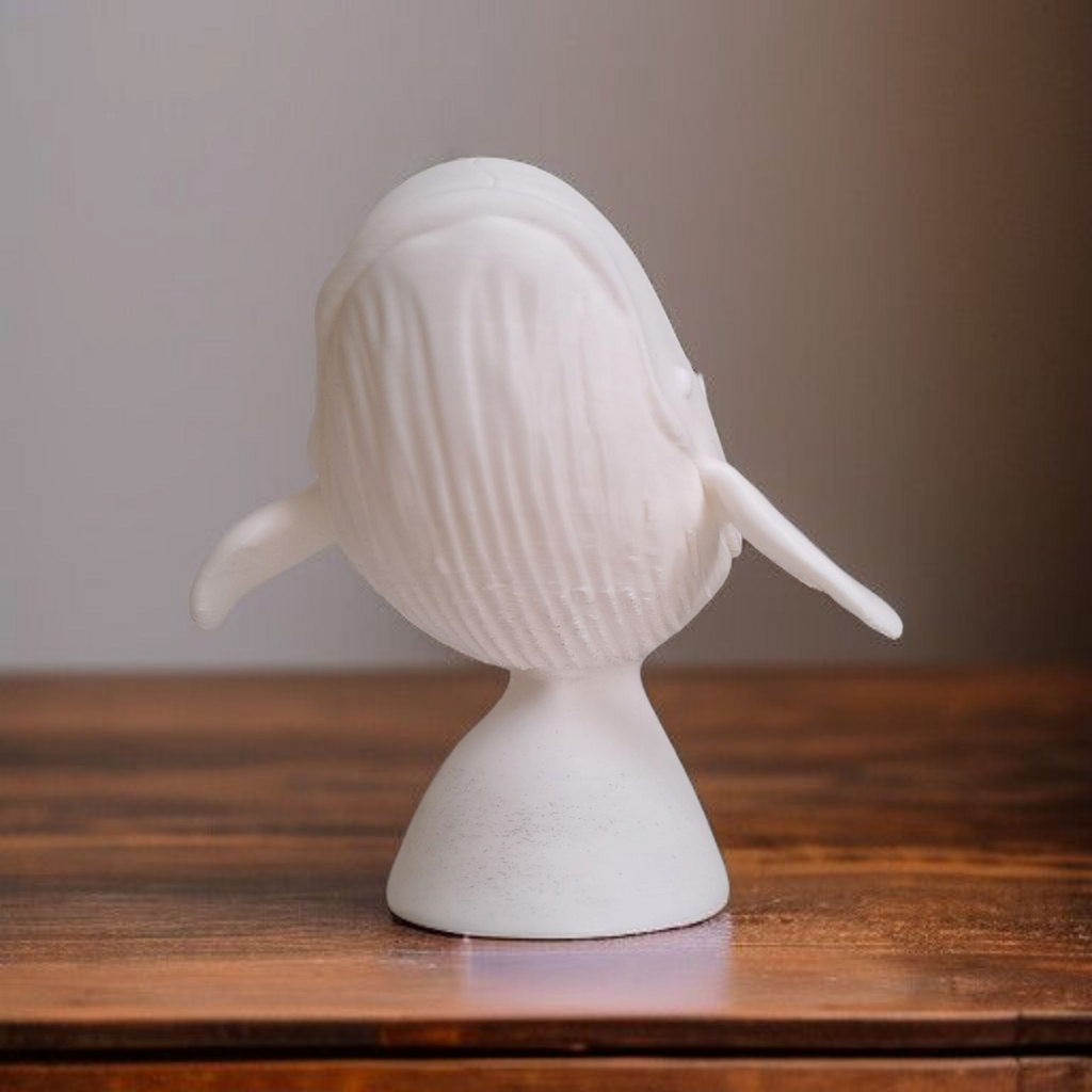 White whale sculpture on a wooden surface with a neutral background