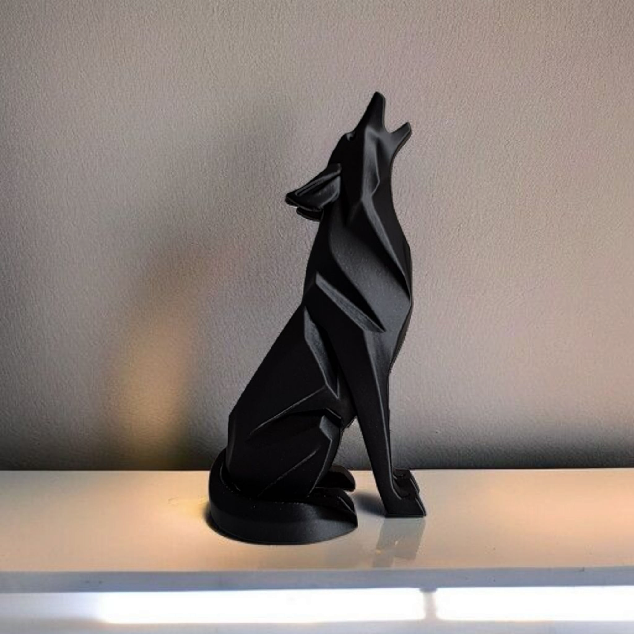 Black wolf sculpture on a reflective surface with a neutral background