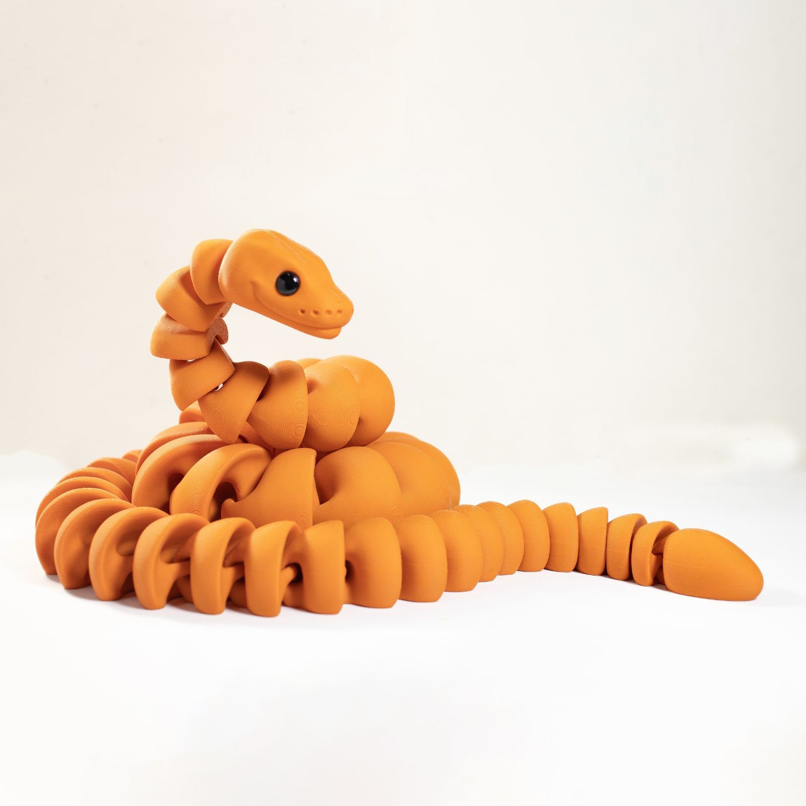 Orange snake-shaped toy on a white background
