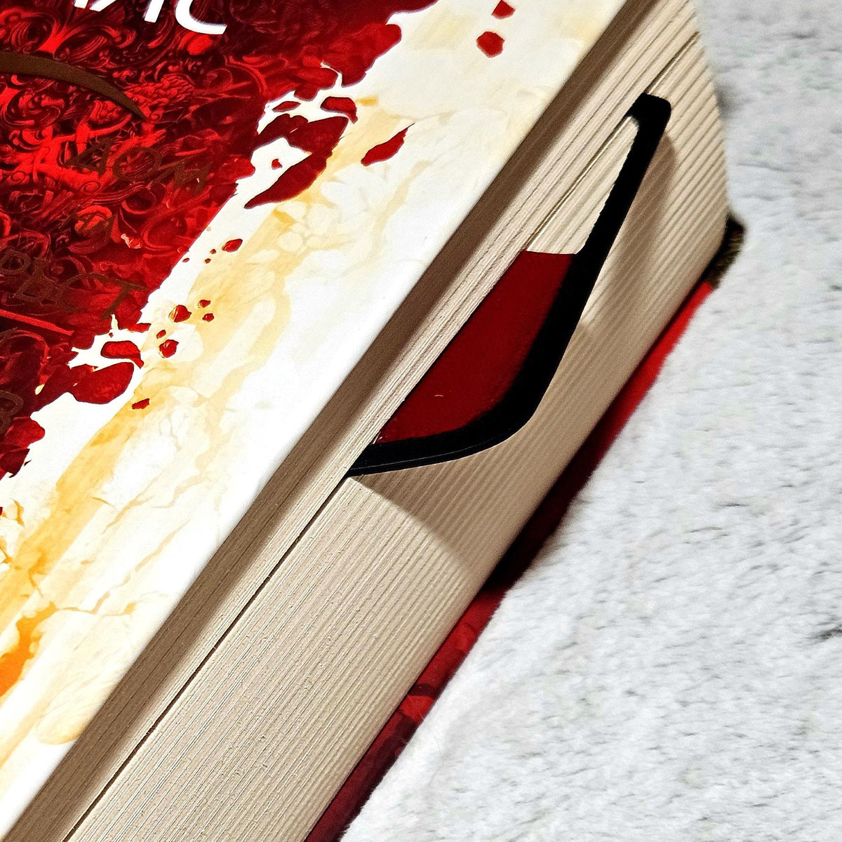 Wine glass bookmark peeking out of the top of a closed book